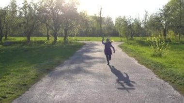 Ellerinde oyuncak uçakla küçük bir kız. Lastik motorun vidalarını sallıyor.