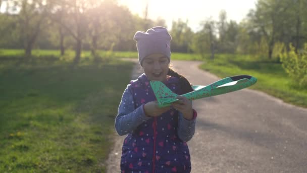Kind spielt mit Flugzeug. Glückliche Mädchen spielen draußen — Stockvideo