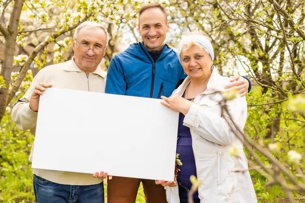 Familie hält Fotoleinwand im Garten — Stockfoto