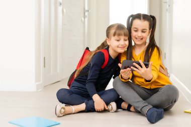 İnsanlar, çocuklar, teknoloji, arkadaşlar ve arkadaşlık konsepti - akıllı telefonları evde yerde yatan mutlu küçük kızlar