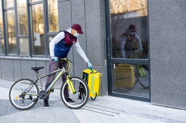 KIEV, UKRAINE - 28 Nisan 2021: Glovo bisikletli kurye. Glovo dağıtım servisinin teslimatçısı.