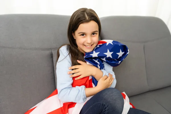 Милая маленькая девочка и флаг США на заднем плане — стоковое фото
