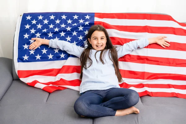 Bella bambina patriottica con la bandiera americana tenuta tra le mani tese — Foto Stock