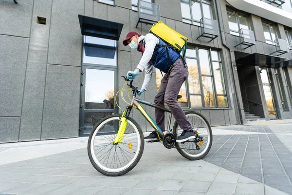 城市里的黄色热背包和自行车。食品交付服务概念. — 图库照片
