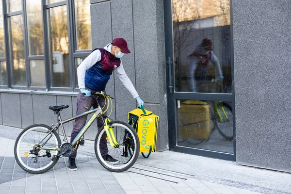 KIEV, UKRAINE - 28 de abril de 2021: Correio de bicicleta Glovo na rua. Rapaz de entrega do serviço de entrega Glovo — Fotografia de Stock