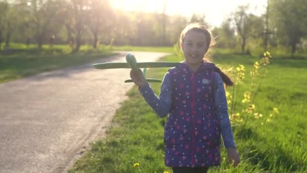 Criança brincando com avião. Menina feliz jogar ao ar livre — Vídeo de Stock