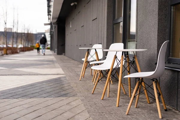 Mesa al aire libre y dos sillas cerca de la pared en la cafetería, —  Fotos de Stock