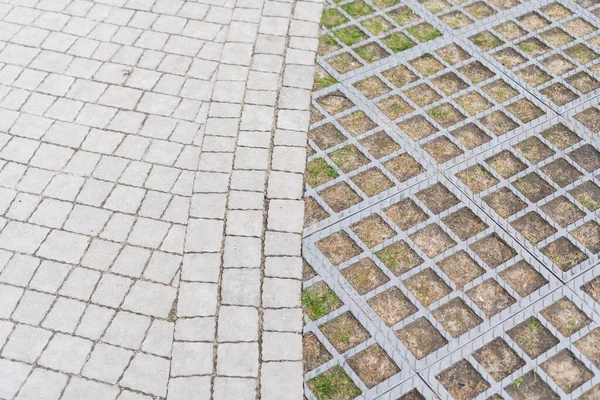 A parkolás geometriai betonja Whith Green Grass. Szürke beton csempe cellákkal ökoparkolás lyukkal füves, felülnézet. — Stock Fotó