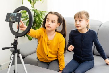 İki liseli blog yazarı. Duygusal jestler. Kamera. Vlog ve blog aboneliklerini kaydet. İnternet için video dersi. Tripodlu kamera kullan.