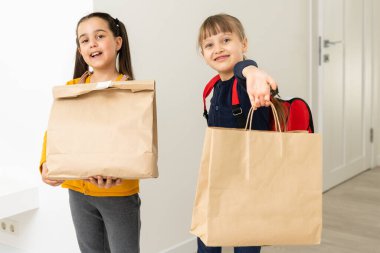 Teslimat paketleri olan iki liseli kız.