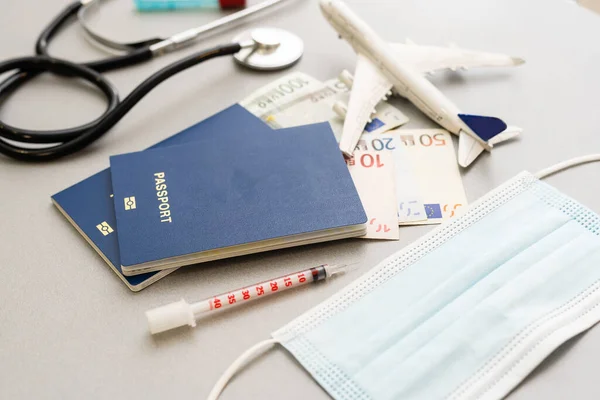 Concept de voyage et de santé. Vue du dessus du masque facial, désinfectant pour les mains, passeport, stéthoscope et avion jouet isolé sur fond bleu avec espace de copie. — Photo