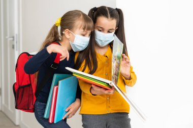 Güvenlik maskesi takan iki çekici kızın yakın plan portresi. Grip salgınını durdurun.