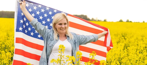 Land, patriotism, självständighetsdag och människor koncept - glad leende ung kvinna med nationell amerikansk flagga på fältet — Stockfoto