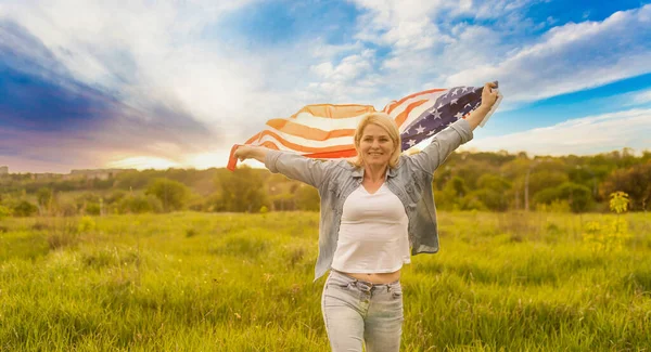 Ülke, vatanseverlik, bağımsızlık günü ve halk konsepti - Ulusal Amerikan bayrağıyla mutlu bir genç kadın sahada — Stok fotoğraf