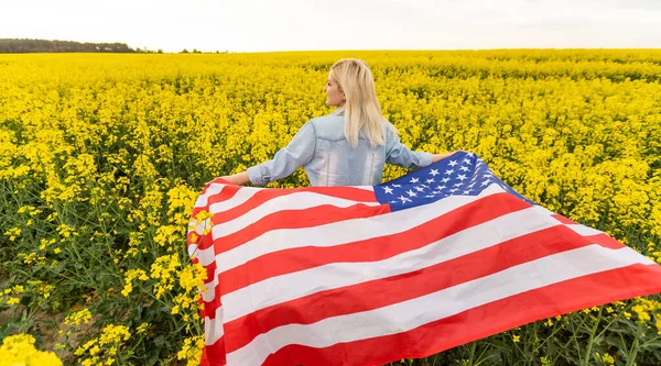 Land, patriotism, självständighetsdag och människor koncept - glad leende ung kvinna med nationell amerikansk flagga på fältet — Stockfoto