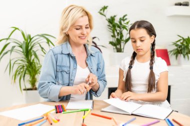 Anne ve kızı evde resim çizerek vakit geçiriyorlar.