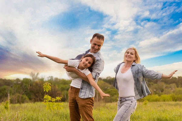 Jovem família feliz em um campo — Fotografia de Stock