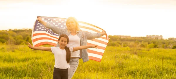 Lycklig mor och dotter med amerikansk flagga utanför — Stockfoto