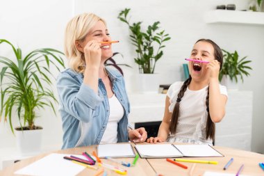 Anne ve kız birlikte ev ödevi yapıyorlar.