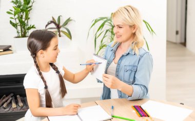 Anne ve kızı evde resim çizerek vakit geçiriyorlar.