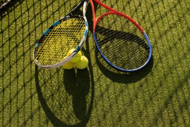 Tenis raketi ve yeni boyanmış tenis kortunda yeni bir tenis topu.