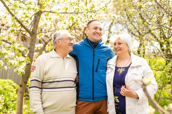 Erwachsener Sohn mit seinen betagten Eltern im Freien in einer natürlichen Umgebung. — Stockfoto