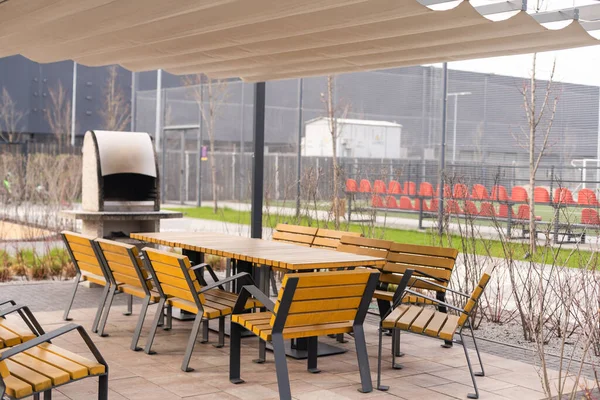La foto muestra una mesa y sillas en una terraza abierta cerca de la cafetería — Foto de Stock