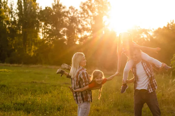 Šťastná rodina při západu slunce v přírodě — Stock fotografie
