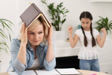 Evdeki oturma odasında annesiyle tartıştıktan sonra konuşmayan mutsuz bir kız.