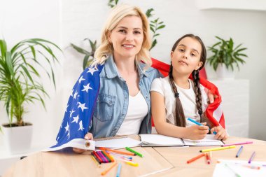 Memleketinde Amerikan bayrağı taşıyan mutlu anne ve kız.