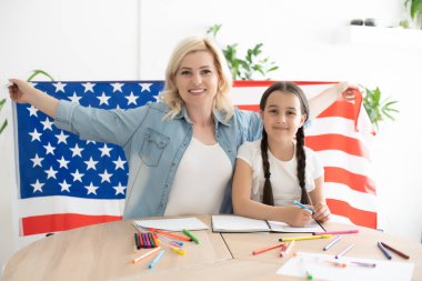 Memleketinde Amerikan bayrağı taşıyan mutlu anne ve kız.