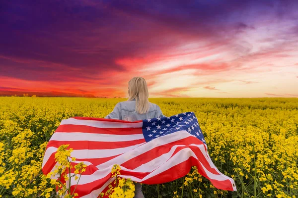 성인기에 막대기와 별 과 줄무늬가 달린 미국 국기를 들고 있는 성인 여성. 바람에 펄럭이는 미국 국기 — 스톡 사진