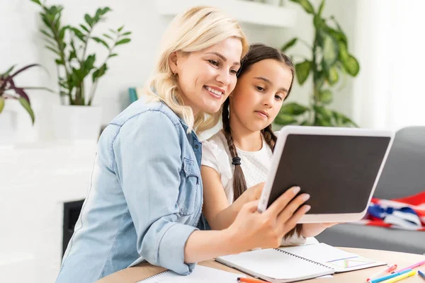 Torniamo a scuola. Bambino felice e adulto sono seduti alla scrivania. Ragazza che fa i compiti o l'educazione online. — Foto Stock