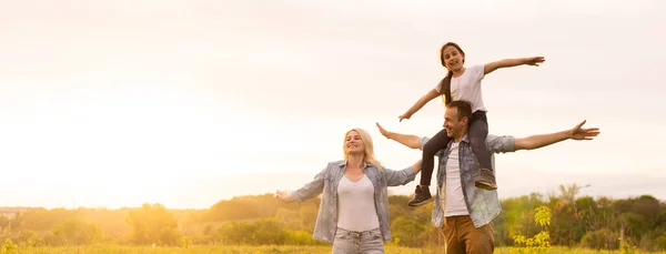 Joven familia feliz en un campo — Foto de Stock