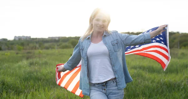 Bir çayırda Amerikan bayrağını tutan kadın. 4 Temmuz - Bağımsızlık Günü. — Stok fotoğraf