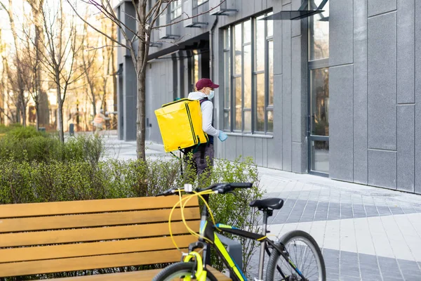 Junger Zusteller mit gelbem Rucksack-Imbiss-Konzept — Stockfoto