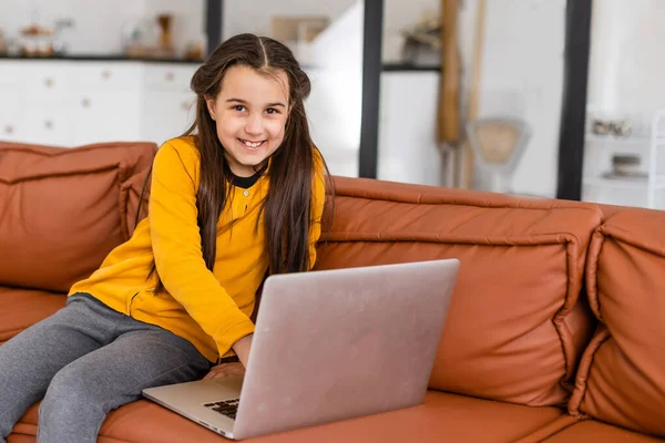 İnternette çocuk. Küçük bir kız evde dizüstü bilgisayarın başında otururken iletişim kurmak için bilgisayarla görüntülü konuşma yapıyor. — Stok fotoğraf