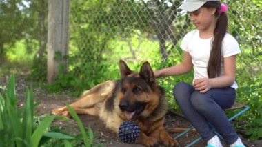 Köpeği Alman çoban köpeği olan neşeli küçük kız.