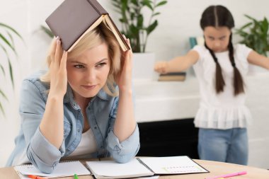 Anne ve kız birlikte ev ödevi yapıyorlar.