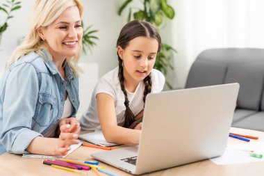 Dizüstü bilgisayar kullanan genç bir kadın.