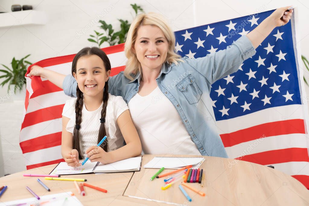 Help with homework is widely required among schoolkids now. Learning English language in USA. English female student with the American flag at the background