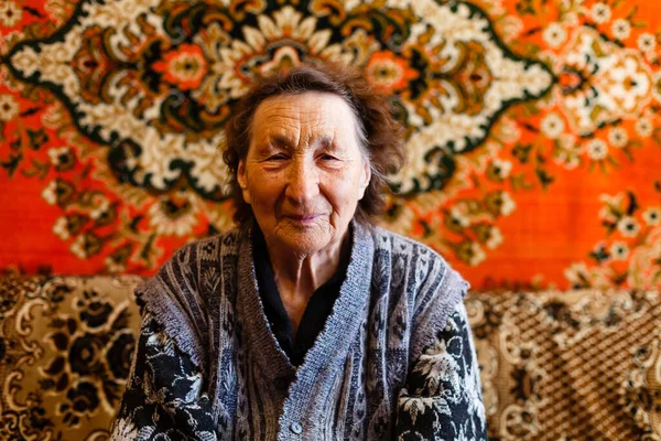 Старшая женщина отдыхает в кресле дома — стоковое фото