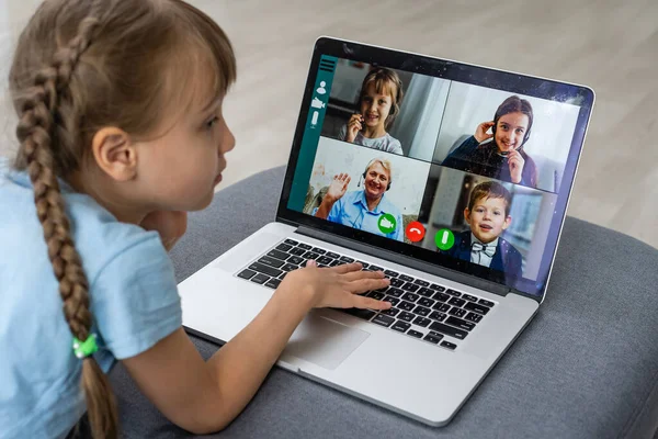 Enseignement à distance. Petite fille joyeuse dans les écouteurs à l'aide d'un ordinateur portable étudiant grâce au système d'apprentissage en ligne. — Photo