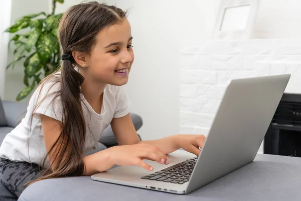 Afstandsonderwijs. Vrolijk meisje meisje in hoofdtelefoon met behulp van laptop studeren via online e-learning systeem. — Stockfoto