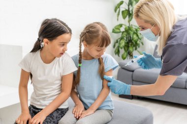 Doktor çocuk aşısı yapıyor.