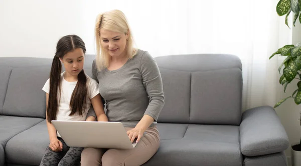 Jovem mulher com menina usando computador portátil — Fotografia de Stock