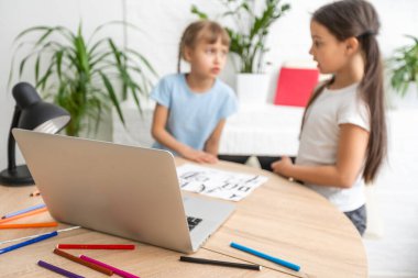 Küçük kız evdeki oturma odasında dizüstü bilgisayarını kullanarak Çince öğreniyor. Aile etkinliği kavramı.