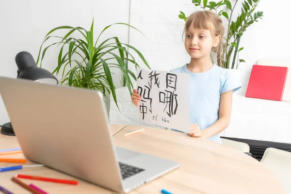 Una niña blanca en la lección de caligrafía china. niña aprendiendo chino — Foto de Stock