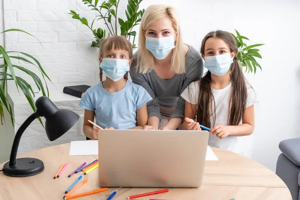 Woman tutor or foster parent mum helping cute caucasian school child girl doing homework sitting at table. Diverse nanny and kid learning writing in notebook studying at home