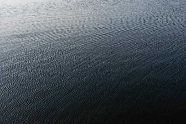 Surface de l'eau avec des ondulations et des reflets de rayons solaires — Photo